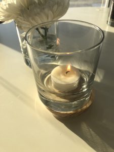 Clear glass vessel with small white tealight, lit